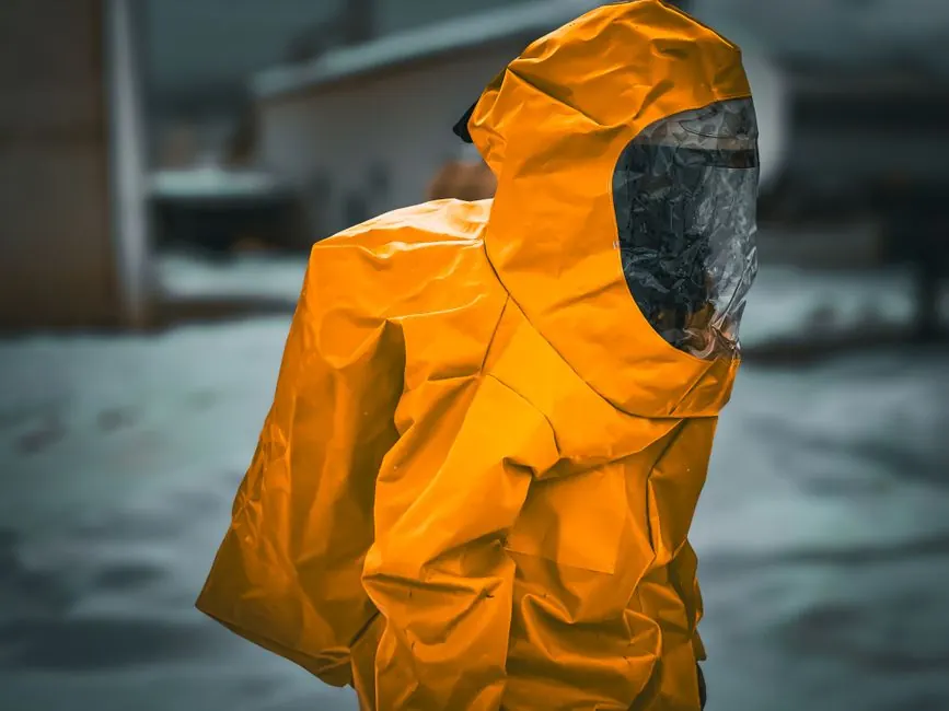 A person wearing a yellow hazmat suit is standing outdoors, creating a dramatic and vivid scene.