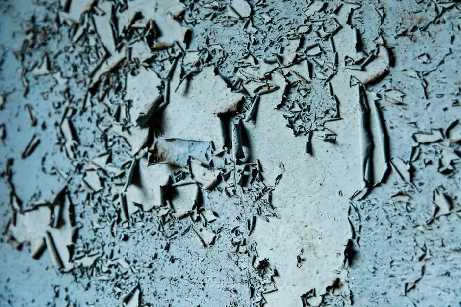 Detailed image of weathered, peeling paint creating an abstract textured pattern.